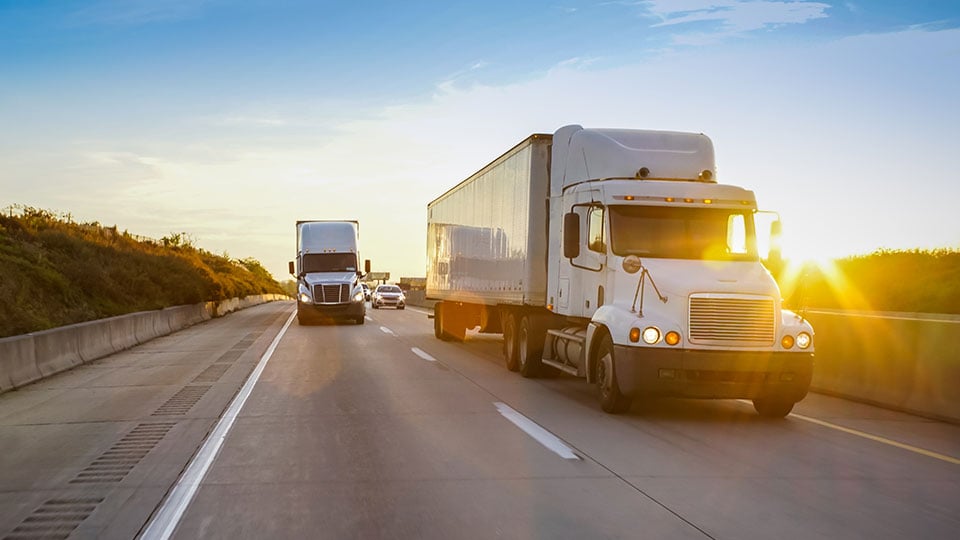 Two-White-Semi-Trucks-on-Highway